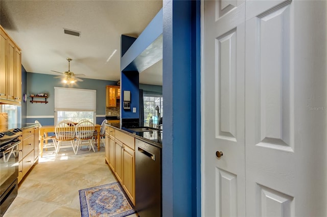 kitchen with dark countertops, visible vents, stainless steel dishwasher, a sink, and black stove