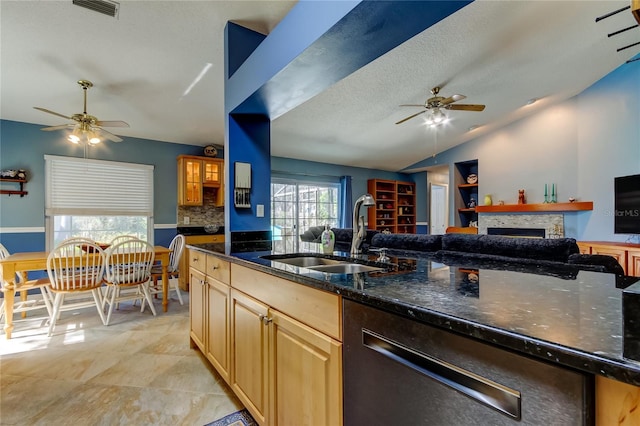 kitchen with a sink, visible vents, a ceiling fan, open floor plan, and vaulted ceiling