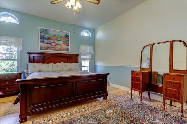 bedroom with baseboards, ceiling fan, and light wood-style floors