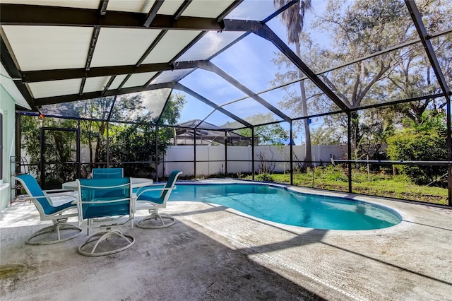 view of swimming pool with a patio area, fence, and a lanai