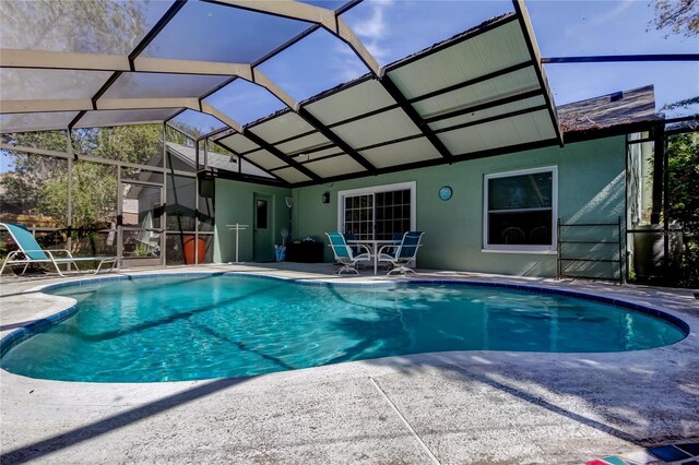 outdoor pool with a patio and glass enclosure