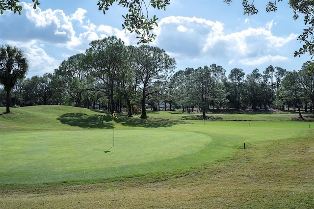 view of community with view of golf course and a lawn