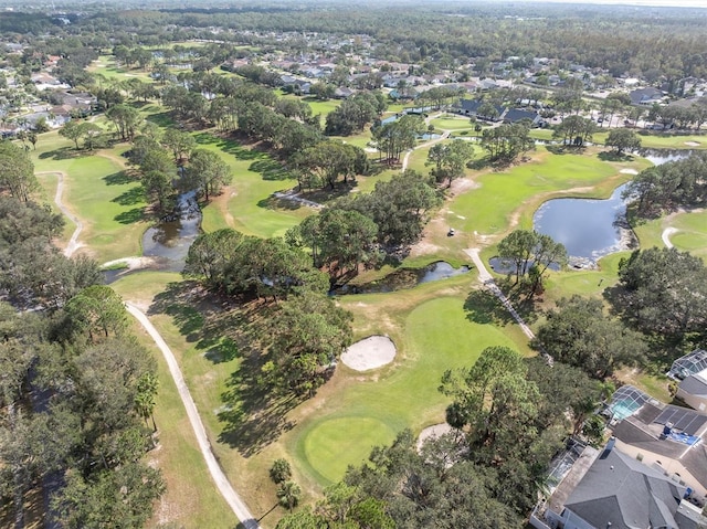 birds eye view of property with view of golf course and a water view