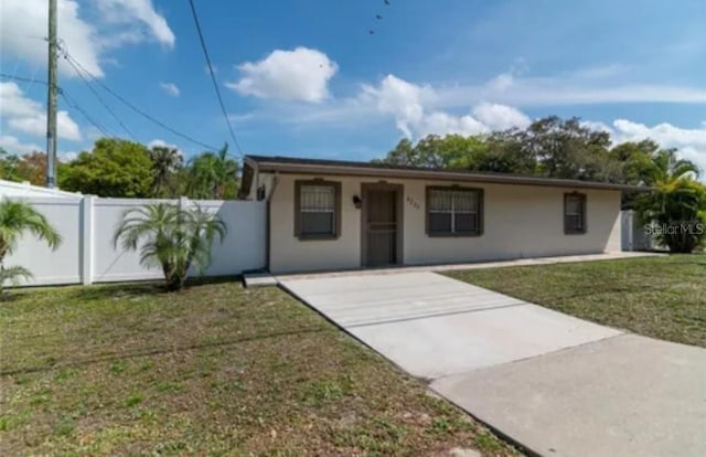 single story home with fence private yard, a front lawn, and stucco siding