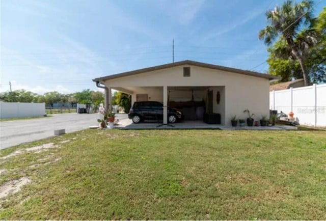 view of parking with driveway and fence