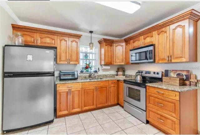 kitchen with hanging light fixtures, light stone countertops, stainless steel appliances, crown molding, and a sink