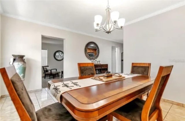 dining space featuring light tile patterned floors, a fireplace, baseboards, ornamental molding, and an inviting chandelier