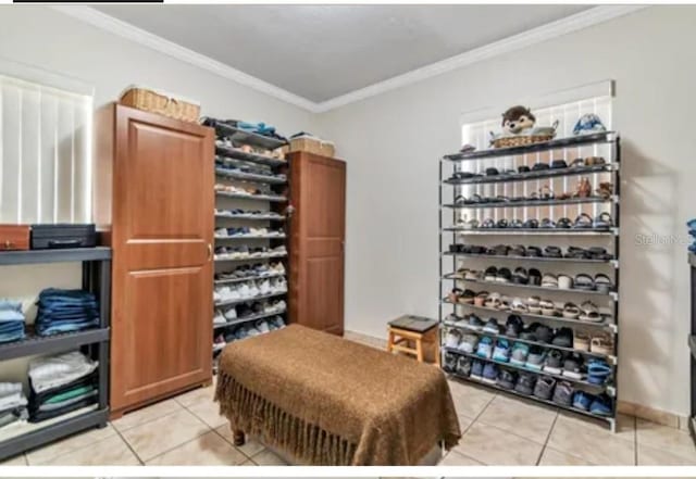 wine cellar featuring ornamental molding and light tile patterned flooring