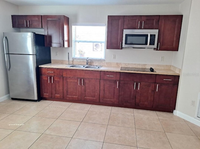 kitchen with a sink, stainless steel appliances, dark brown cabinets, and light countertops