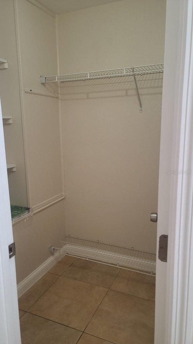 spacious closet featuring tile patterned flooring