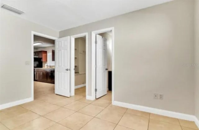 unfurnished room featuring visible vents, baseboards, and light tile patterned floors