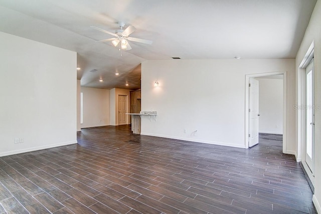 spare room featuring a ceiling fan, lofted ceiling, dark wood finished floors, and baseboards