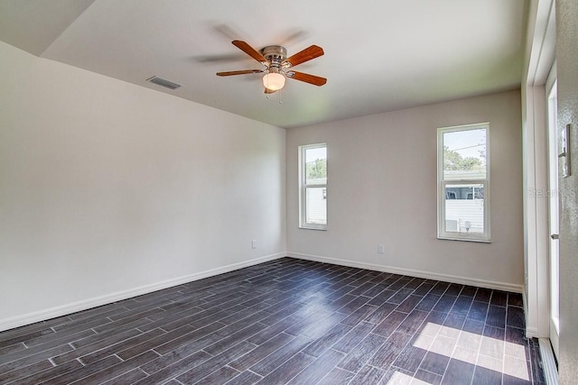 spare room with wood tiled floor, visible vents, plenty of natural light, and baseboards