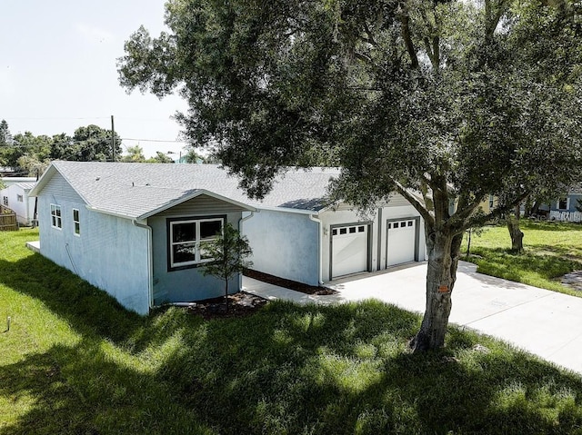 view of front facade with concrete driveway, a front lawn, an attached garage, and stucco siding