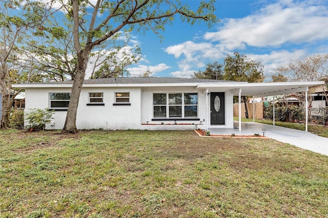 ranch-style house with brick siding, fence, a carport, driveway, and a front lawn