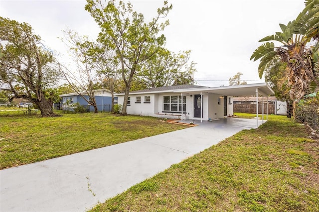 ranch-style home featuring a carport, a front lawn, concrete driveway, and fence