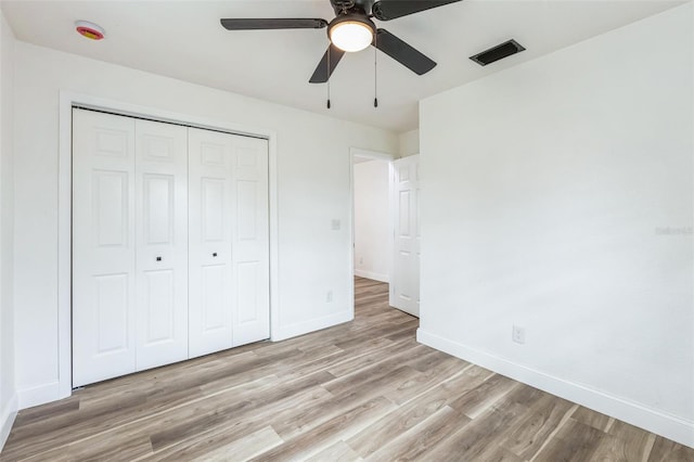 unfurnished bedroom featuring a closet, visible vents, a ceiling fan, light wood-type flooring, and baseboards