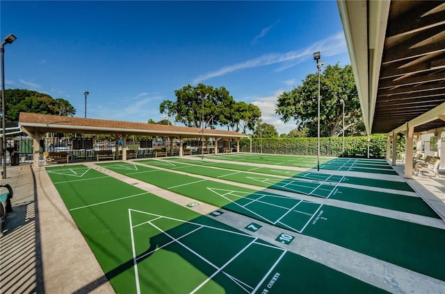 view of home's community featuring shuffleboard and fence