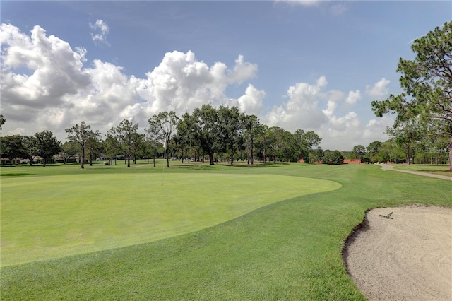 view of community with a lawn and view of golf course