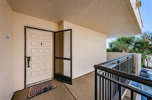 doorway to property featuring a balcony and stucco siding