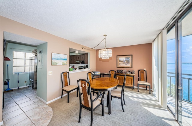 dining room with light carpet, a textured ceiling, baseboards, and an inviting chandelier