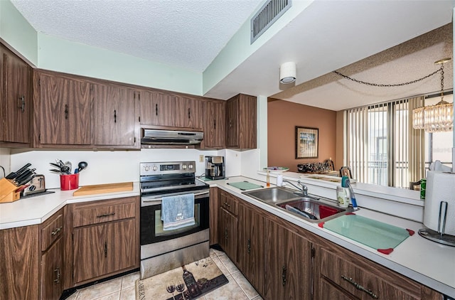 kitchen featuring a textured ceiling, visible vents, electric stove, light countertops, and range hood