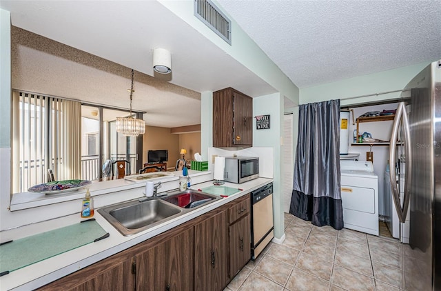 kitchen with dark brown cabinetry, visible vents, appliances with stainless steel finishes, washer / clothes dryer, and light countertops