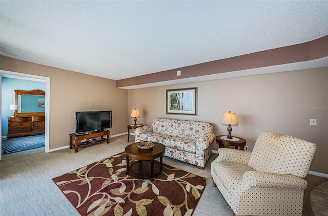 living room with carpet, baseboards, and a textured ceiling