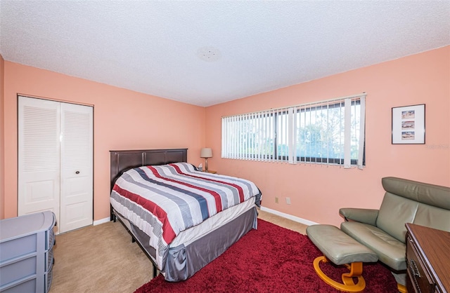 bedroom featuring a closet, carpet flooring, a textured ceiling, and baseboards