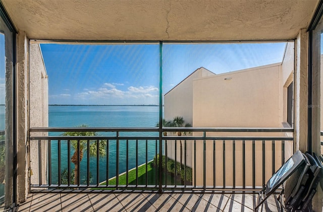 unfurnished sunroom featuring a water view