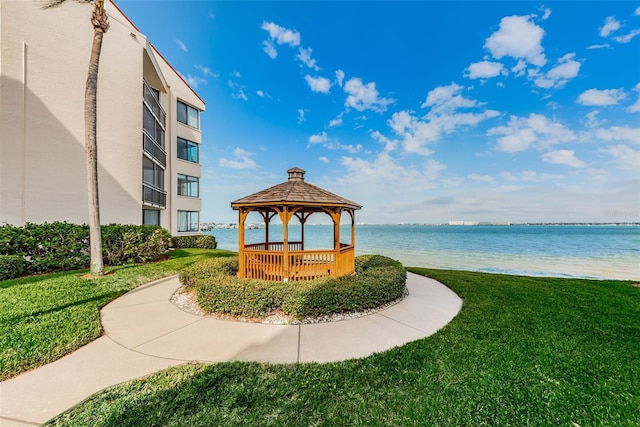 view of property's community with a gazebo, a yard, and a water view