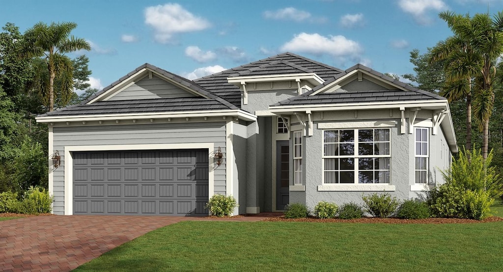 view of front facade featuring decorative driveway, an attached garage, a front yard, and stucco siding