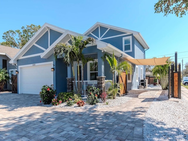 view of front of property featuring a garage, decorative driveway, covered porch, and stucco siding