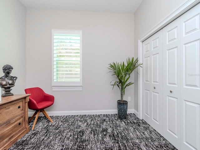 living area featuring carpet flooring and baseboards