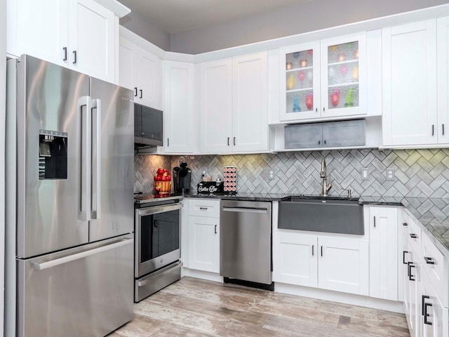 kitchen featuring appliances with stainless steel finishes, backsplash, and white cabinets