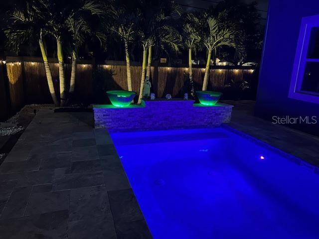 view of swimming pool featuring fence private yard and a patio