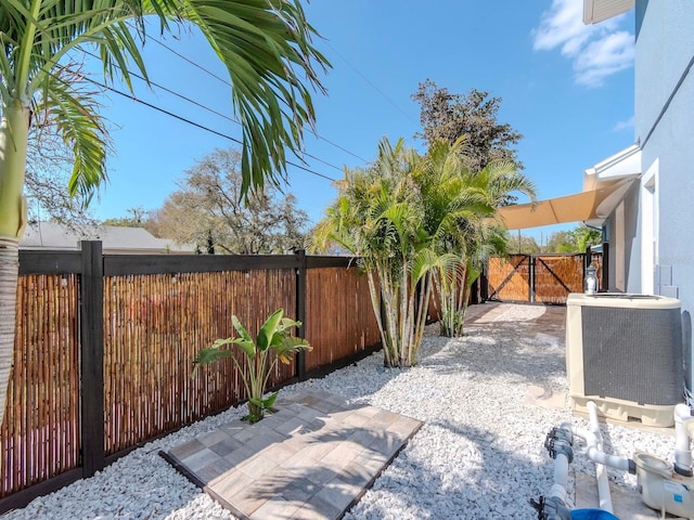 view of patio featuring a gate, a fenced backyard, and central AC unit