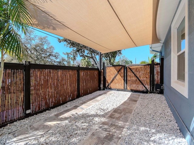 view of patio featuring fence and a gate