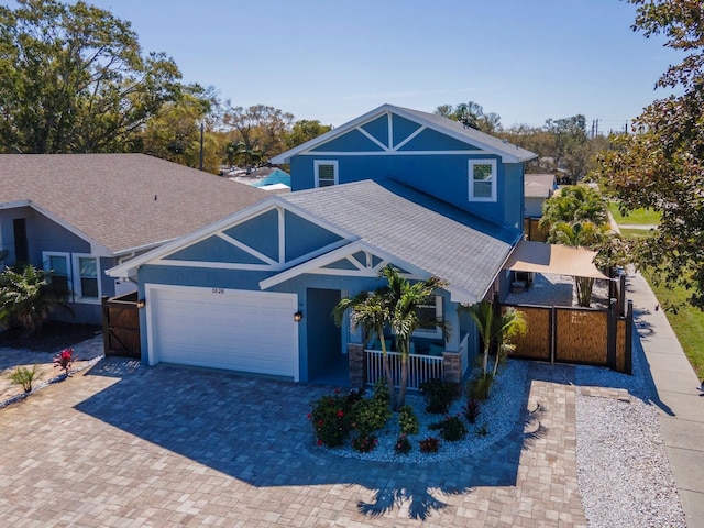 view of front of home featuring an attached garage, covered porch, decorative driveway, and stucco siding