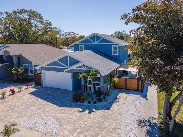 view of front of home featuring an attached garage, covered porch, a shingled roof, decorative driveway, and stucco siding