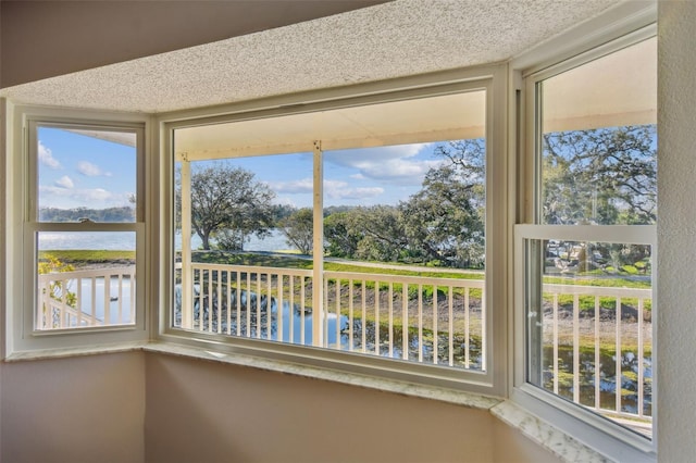 unfurnished sunroom with a water view