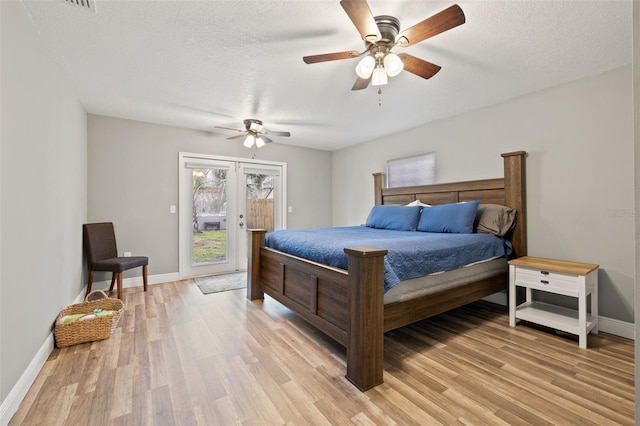 bedroom featuring access to exterior, french doors, light wood-style floors, a textured ceiling, and baseboards