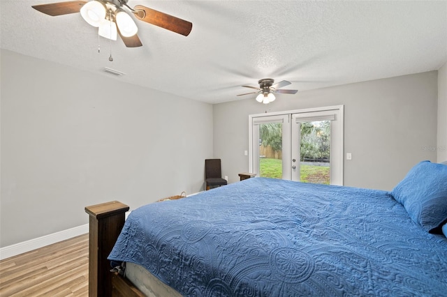 bedroom featuring wood finished floors, visible vents, baseboards, access to exterior, and french doors