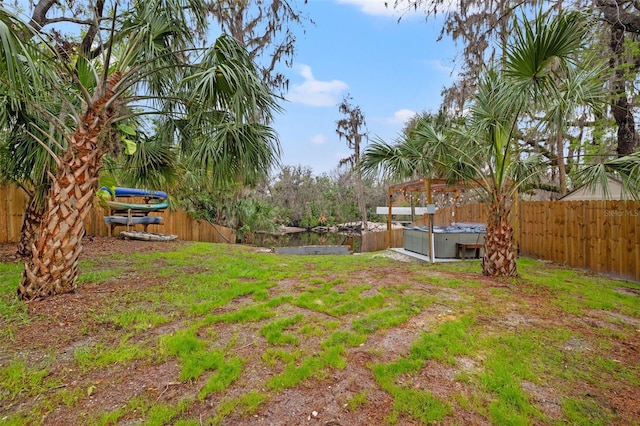 view of yard featuring a fenced backyard and a hot tub