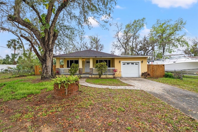 single story home with a porch, a garage, fence, concrete driveway, and stucco siding