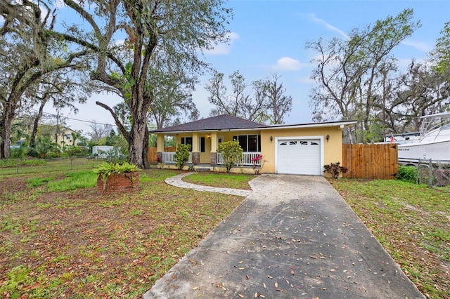 view of front of house with stucco siding, covered porch, an attached garage, fence, and driveway