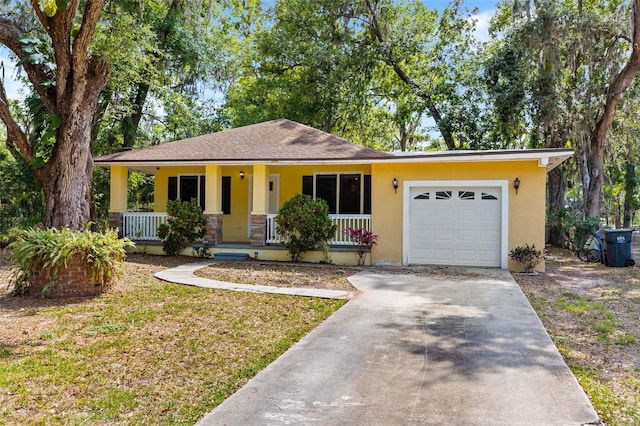 ranch-style home featuring a porch, an attached garage, driveway, stucco siding, and a front yard