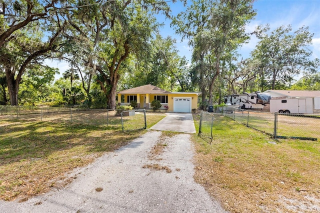 view of front facade featuring driveway, an attached garage, fence private yard, and a front yard