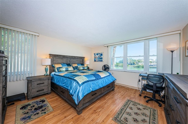 bedroom featuring a textured ceiling and light wood finished floors