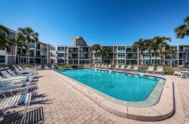 community pool with a patio area and fence